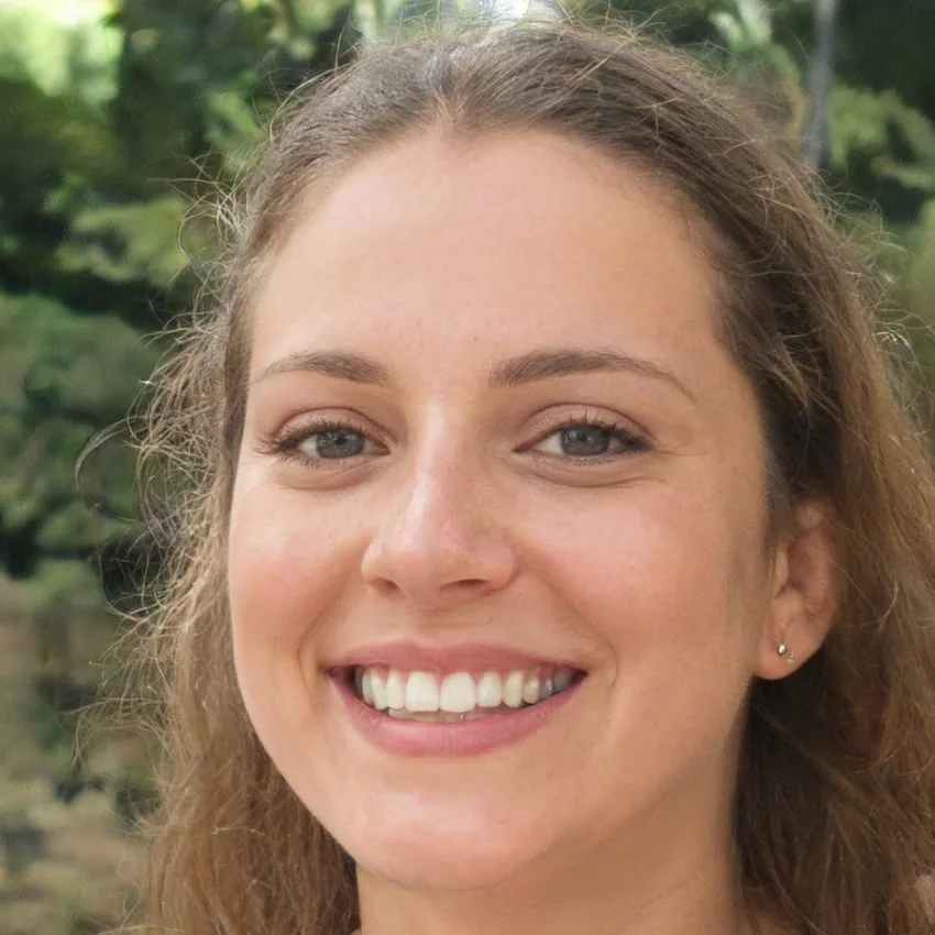 Portrait of Emily Roberts, smiling outdoors with natural greenery in the background.